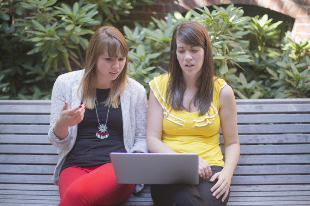 two girls on bench reviewing offensive email